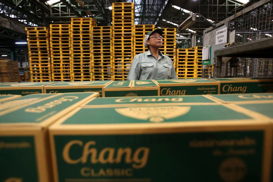 A worker inspects boxes of Thai Beverage Pcl (ThaiBev) Chang beer as they move along the production line at the company's Beer Thip brewery in Bang Ban, Ayutthaya province, Thailand, on Friday, Oct. 5, 2012. ThaiBev, controlled by billionaire Charoen Sirivadhanabhakdi, was one of the companies that backed Heineken NV's offer to buy out Fraser & Neave Ltd.'s beer business. Photographer: Dario Pignatelli/Bloomberg
