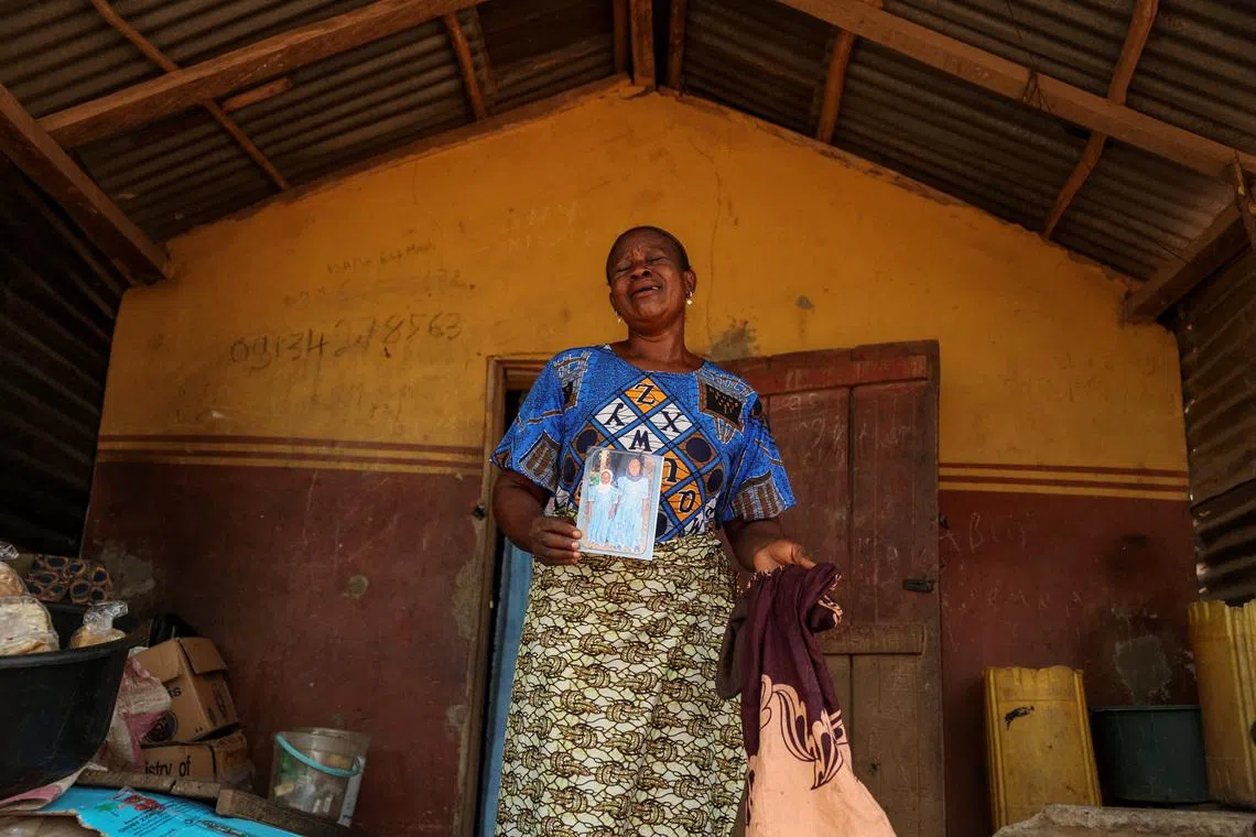 Aduke Balogun, whose daughter was among dozens of pupils and teachers abducted in a large-scale school attack in southwestern Nigeria, reacts while displaying her daughter's photograph and clothing after an interview with Reuters at her home in Yawota, Oyo State, Nigeria, June 2, 2026. REUTERS/Sodiq Adelakun
