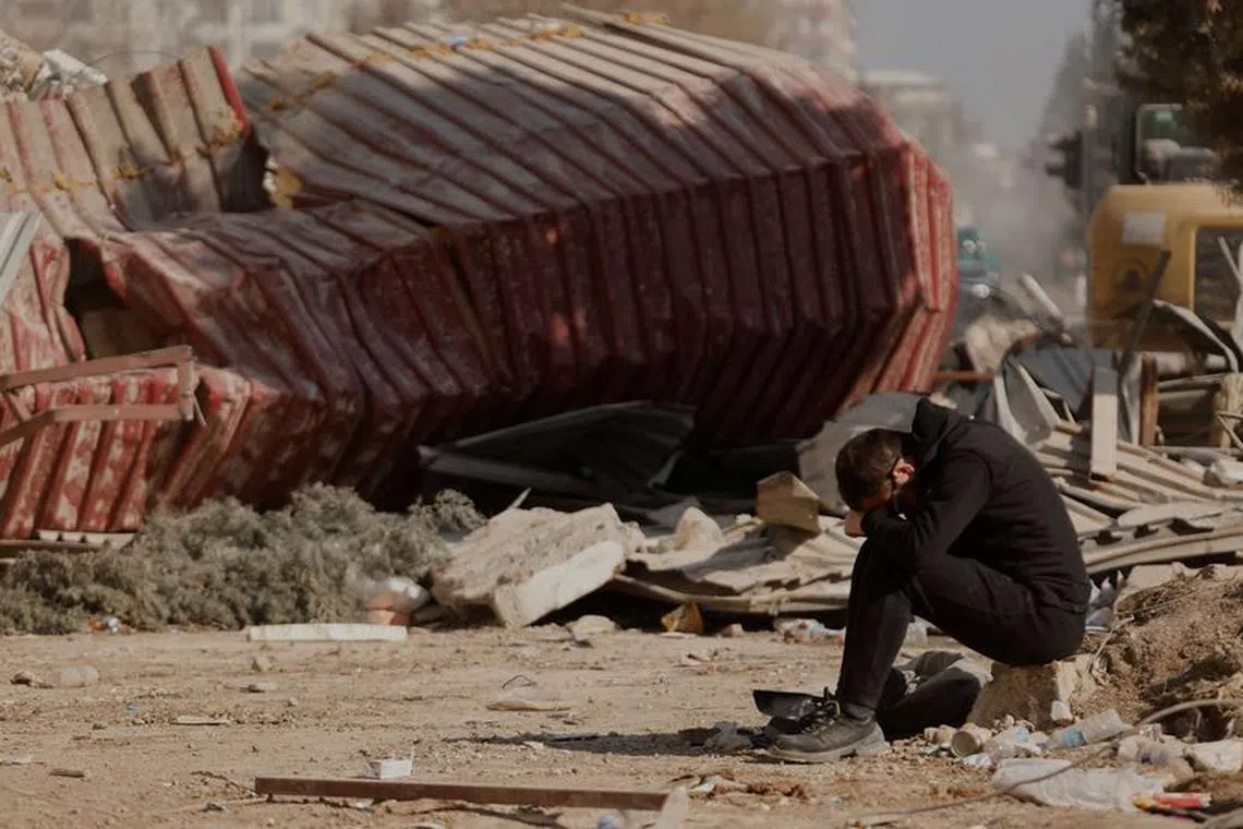 FILE PHOTO: A man reacts as people search the rubble of collapsed apartment blocks for personal belongings, in the aftermath of a deadly earthquake, in Kahramanmaras, Turkey, February 18, 2023. REUTERS/Clodagh Kilcoyne