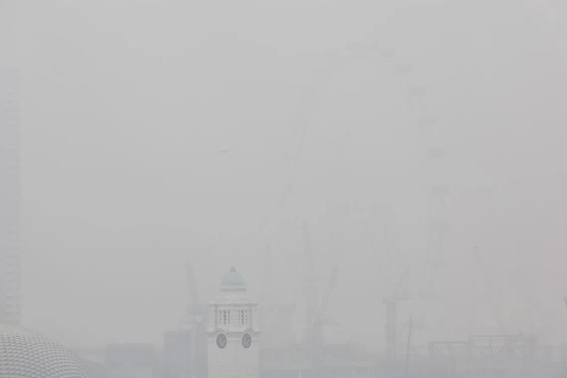 The Singapore Flyer and surrounding buildings are shrouded in thick haze, seen from Chinatown at around 1.05pm on Oct 14, 2026.