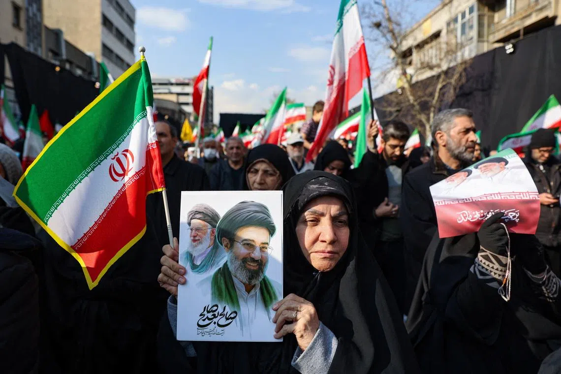 A woman holds a placard with an image of Iran's new supreme leader Mojtaba Khamenei alongside late Iranian Supreme Leader Ayatollah Ali Khamenei in Tehran, Iran, March 9, 2026. Majid Asgaripour/WANA (West Asia News Agency) via REUTERS