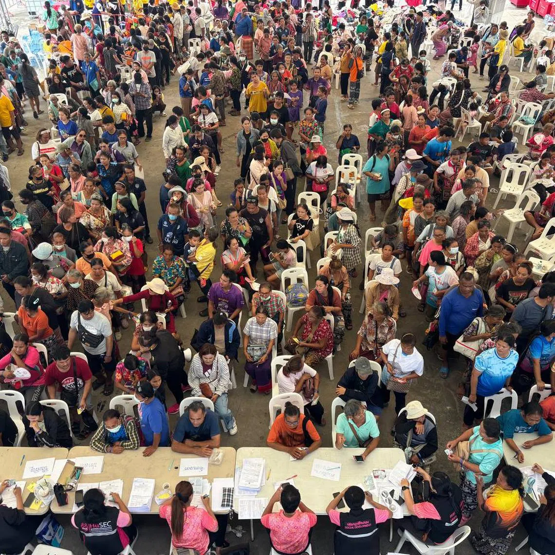 Thai residents queuing to register their details with authorities at an evacuation centre in Buriram.