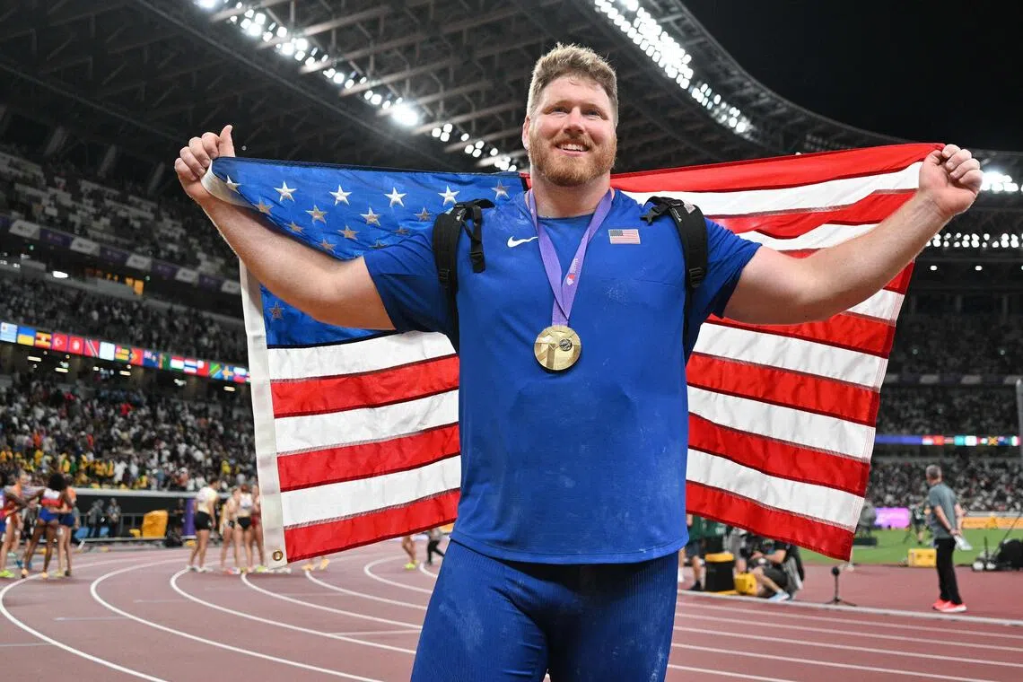 Ryan Crouser celebrates with his gold medal and the US national flag after winning the men's shot put final.
