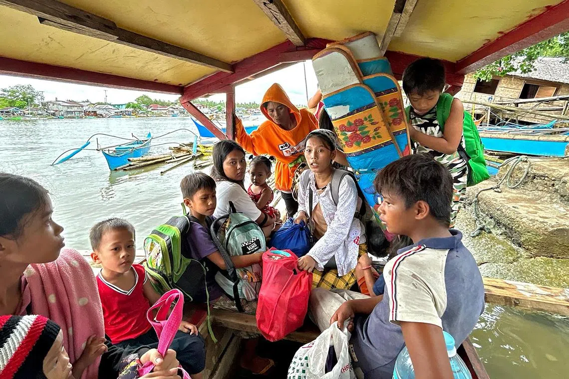 Earthquake-affected residents ride a boat as they evacuate from Hinatuan, Surigao del Sur province on Dec 3, following a 7.6 magnitude quake late on Dec 2. 