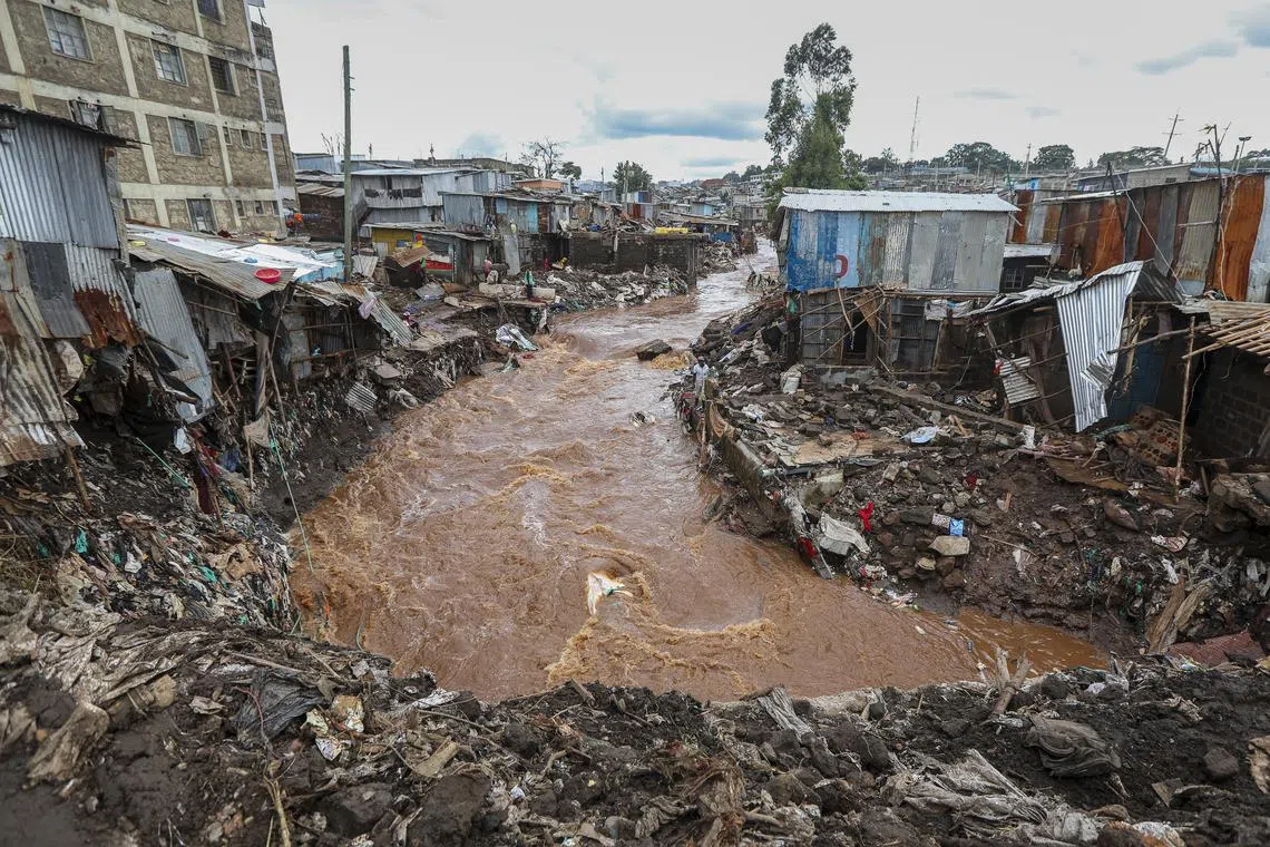 People inspecting damaged houses at an area flooded by the Gitathuru river, a day after it overflowed and broke its banks due to heavy rainfall damaging surrounding neighborhoods, in the Mathare slums, Nairobi, Kenya, on April 25, 2024. 
