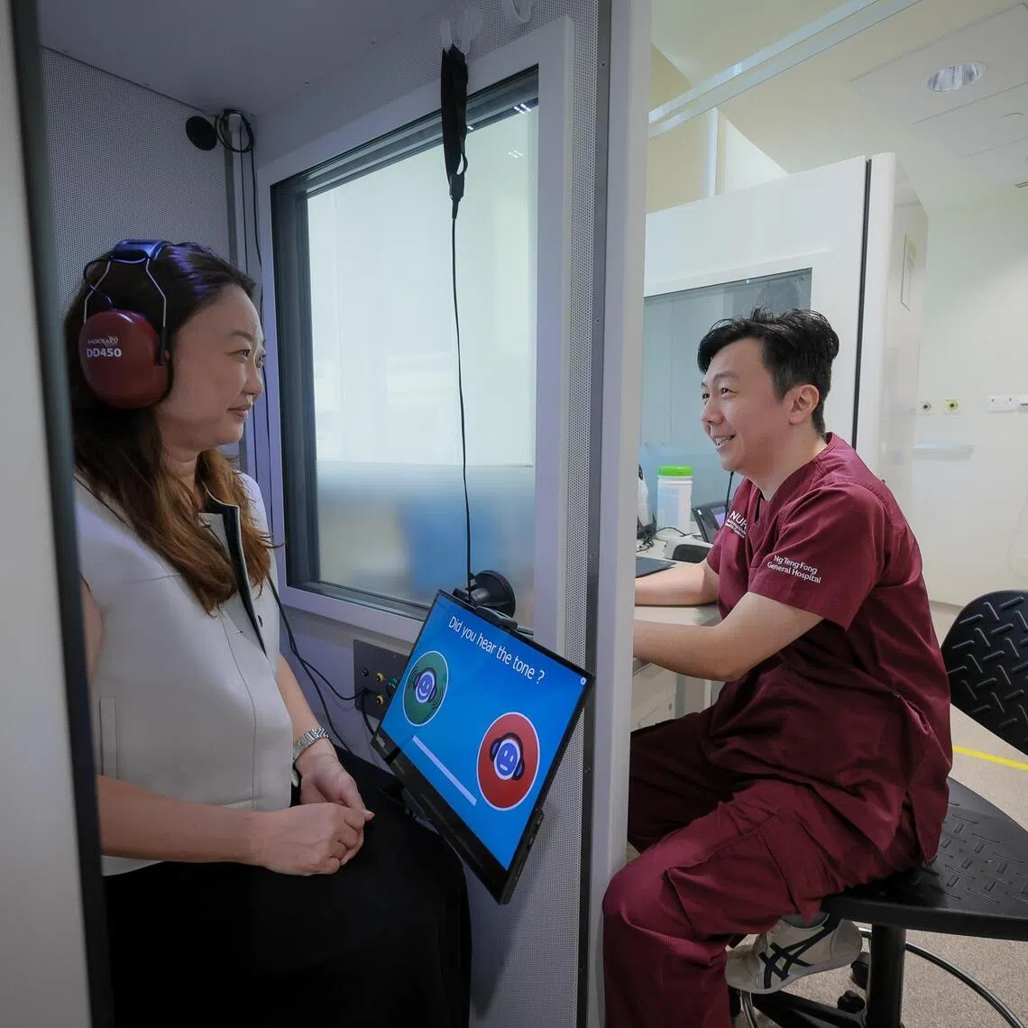Head of Audiology at Ng Teng Fong General Hospital Remy New demonstrates a hearing test using a portable audiometry booth at Ng Teng Fong General Hospital on June 19.