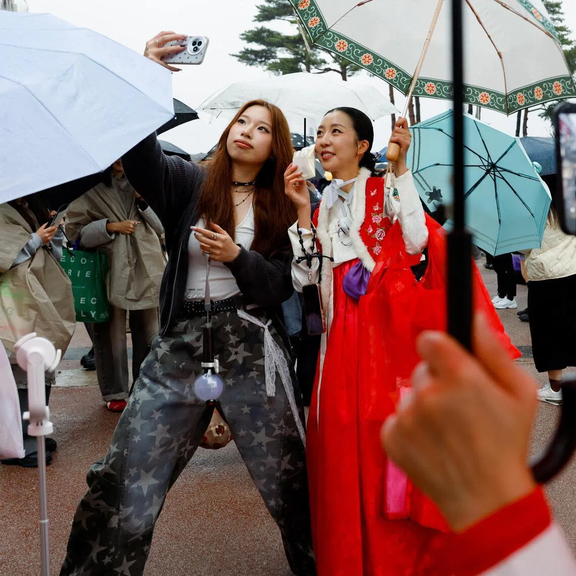 A BTS fan wearing Korean traditional clothing Hanbok, takes a selfie ahead of the band's concert in Goyang, on April 9.
