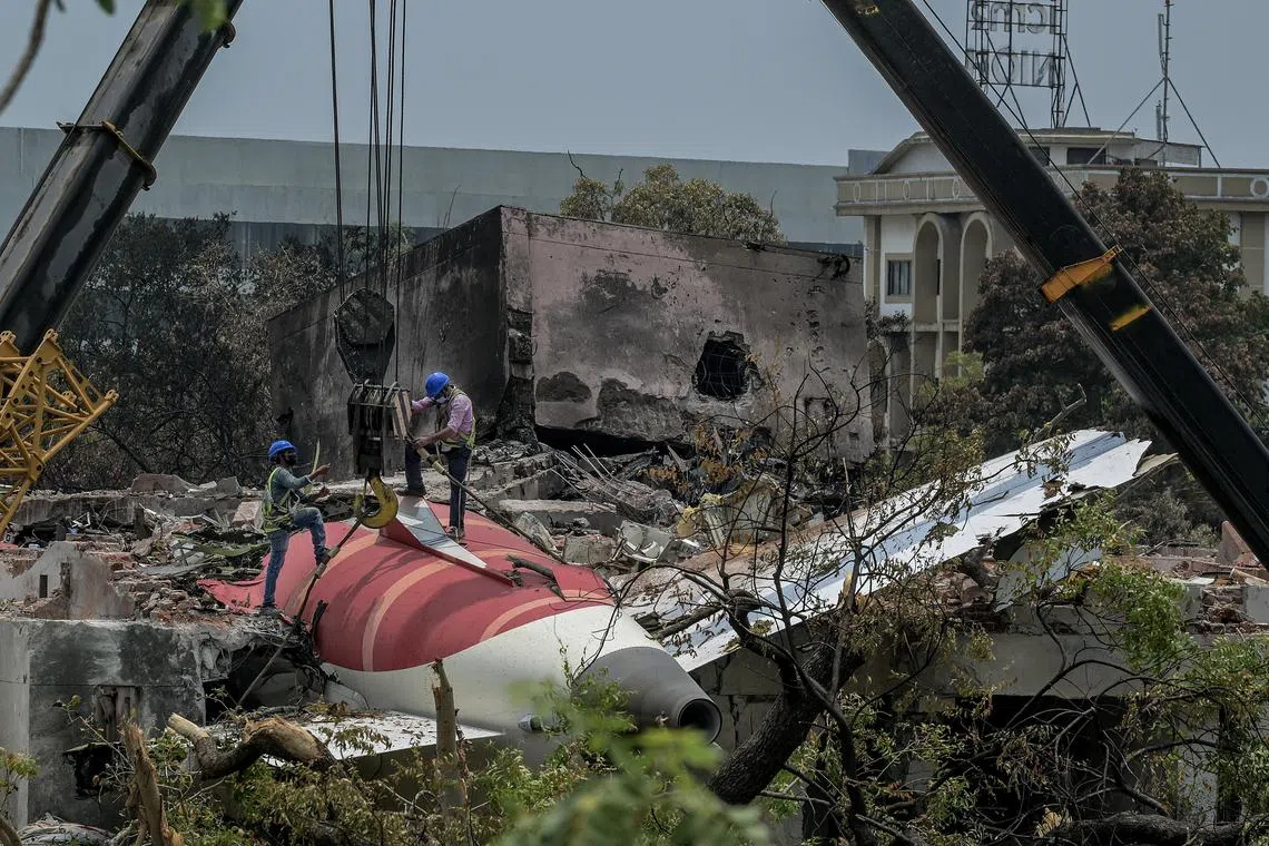 Workers prepare to remove the tail section of Air India Flight AI171 from the crash site in Ahmedabad, India, on June 14. 