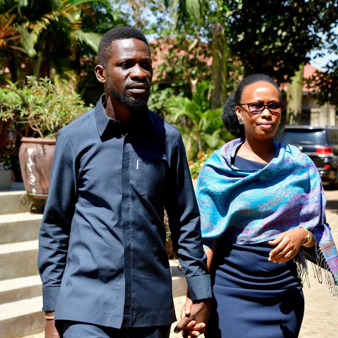 FILE PHOTO: Ugandan Presidential candidate Robert Kyagulanyi, also known as Bobi Wine, of the National Unity Platform (NUP) party, walks with his wife Barbara Kyagulanyi, after he addressed a press conference as they prepare to leave their Magere home to vote in the general election, in Kasangati town near Kampala, Uganda January 15, 2026. REUTERS/Abubaker Lubowa/File Photo