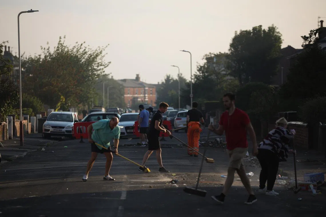 epa11510731 Workers and local residents sweep debris from Windsor Road after a night of disorder in Southport, Britain, 31 July 2024. Merseyside Police issued a statement that 22 Police officers were injured during a night of violent disorder in Southport, with cars set alight & a shop broken into & looted. ‘A 24-hour Section 60 Order has been introduced and extra officers will remain in the area to provide a visible presence to reassure communities’, the police added.  EPA-EFE/ADAM VAUGHAN