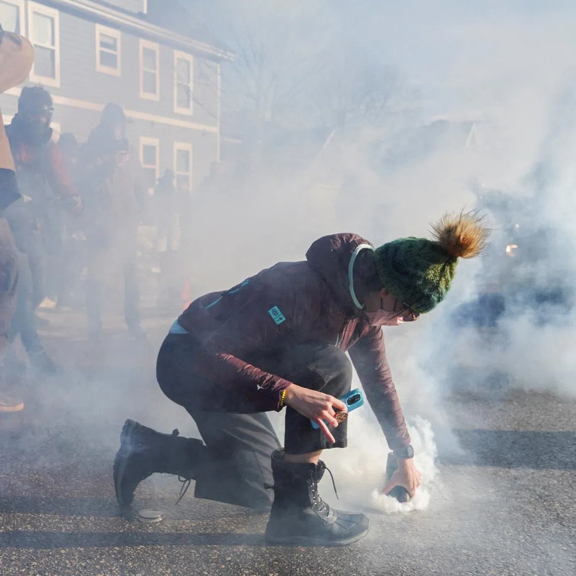 A person covers a tear gas canister used by federal agents during an immigration raid days after an ICE agent fatally shot Renee Nicole Good, in Minneapolis, Minnesota, U.S., January 13, 2026. REUTERS/Ryan Murphy