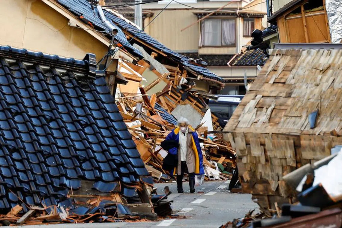 A woman, whose house was damaged by an earthquake carries her belongings as she heads to an evacuation centre, in Wajima, Ishikawa Prefecture, Japan, January 5, 2024. REUTERS/Kim Kyung-Hoon