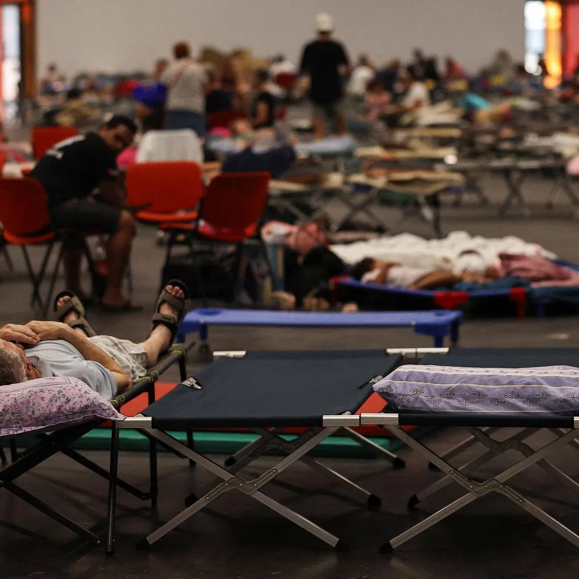 A man rests at the Bordeaux-Lac Exhibition Centre, which has been turned into a shelter for people displaced by a wildfire burning nearby amid worsening drought conditions following a heatwave and water shortages across much of France, in Bordeaux, France, July 25, 2026. REUTERS/Manon Cruz