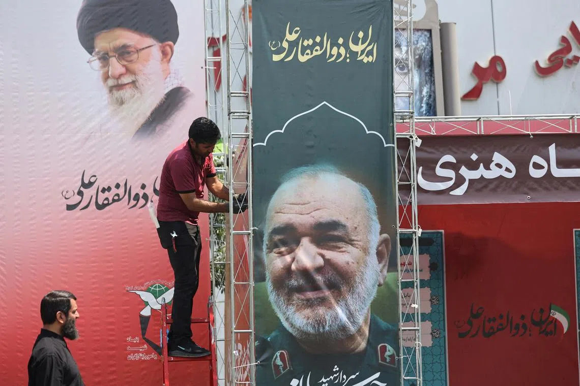 FILE PHOTO: A man installs a banner with a picture of late Islamic Revolutionary Guard Corps (IRGC) Commander-in-Chief Major General Hossein Salami, following the Israeli strikes on Iran, in Tehran, June 14, 2025. Majid Asgaripour/WANA (West Asia News Agency) via REUTERS/ File Photo