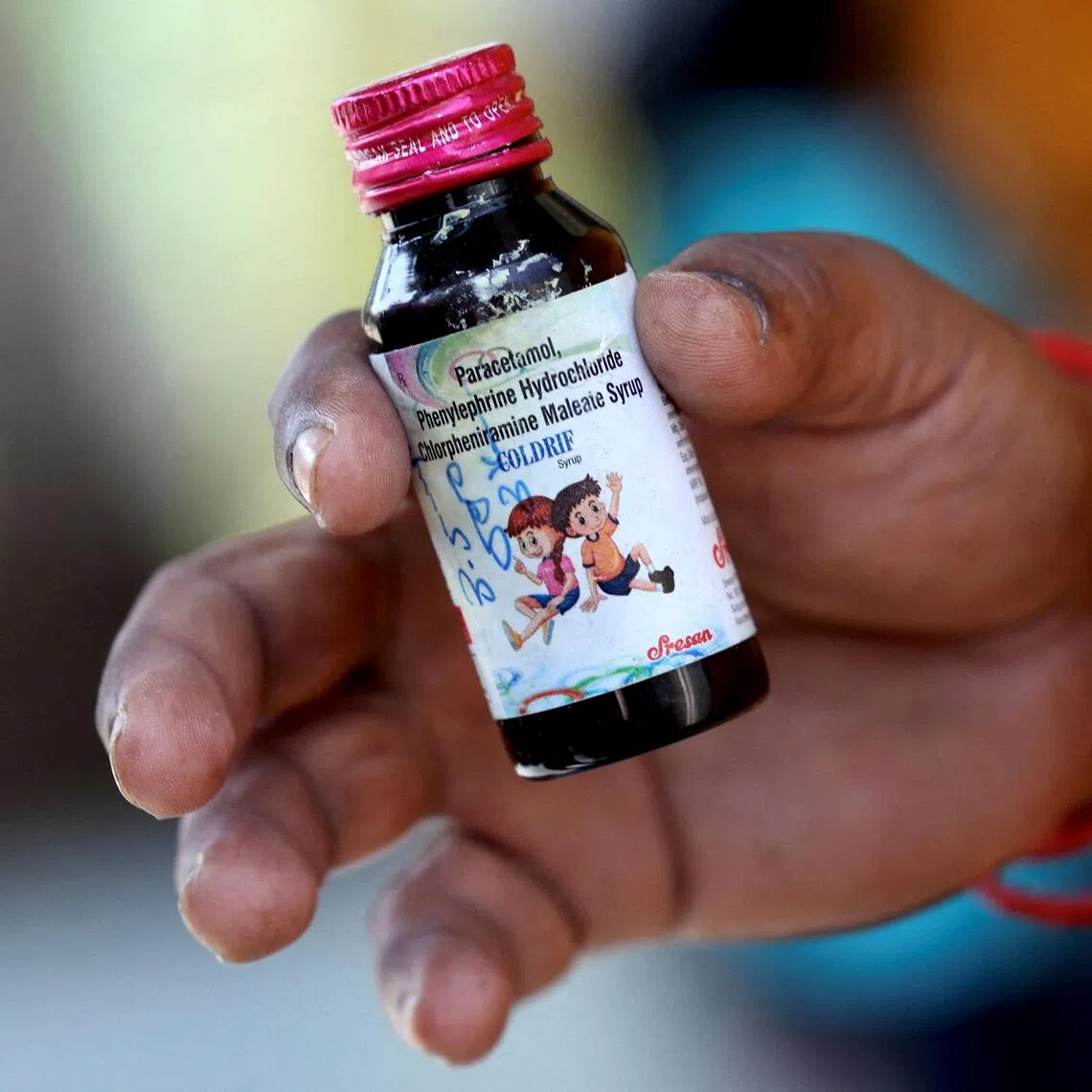 Nilesh Suryavanshi, 32, the father of a 3 year old child who has been admitted at the Government Medical College, holds a bottle of Coldrif cough syrup, which has been linked to the deaths of 17 children, in Nagpur, India, October 8, 2025. REUTERS/Priyanshu Singh