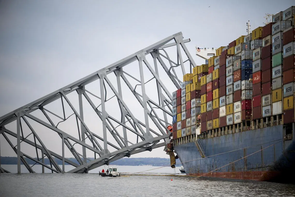 FILE — A small boat works alongside the Dali container ship with the collapsed Francis Scott Key Bridge in Baltimore, Md., March 30, 2024. The body of the sixth and final victim who died in the collapse of the Francis Scott Key Bridge in Baltimore was found on Tuesday, May 7, 2024, officials said, bringing to a close a difficult salvage mission after the country’s deadliest bridge collapse in more than a decade. (Pete Kiehart/The New York Times)