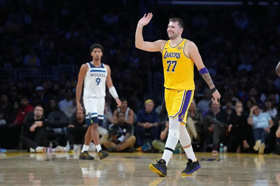Los Angeles Lakers guard Luka Doncic celebrates in the second half as Minnesota Timberwolves guard Johnny Juzang watches.