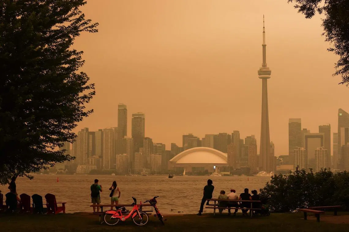 People look toward the downtown skyline from the Toronto Islands as forest fires in Northern Ontario cause poor air quality over the city, in Toronto, Ontario, on July 15.