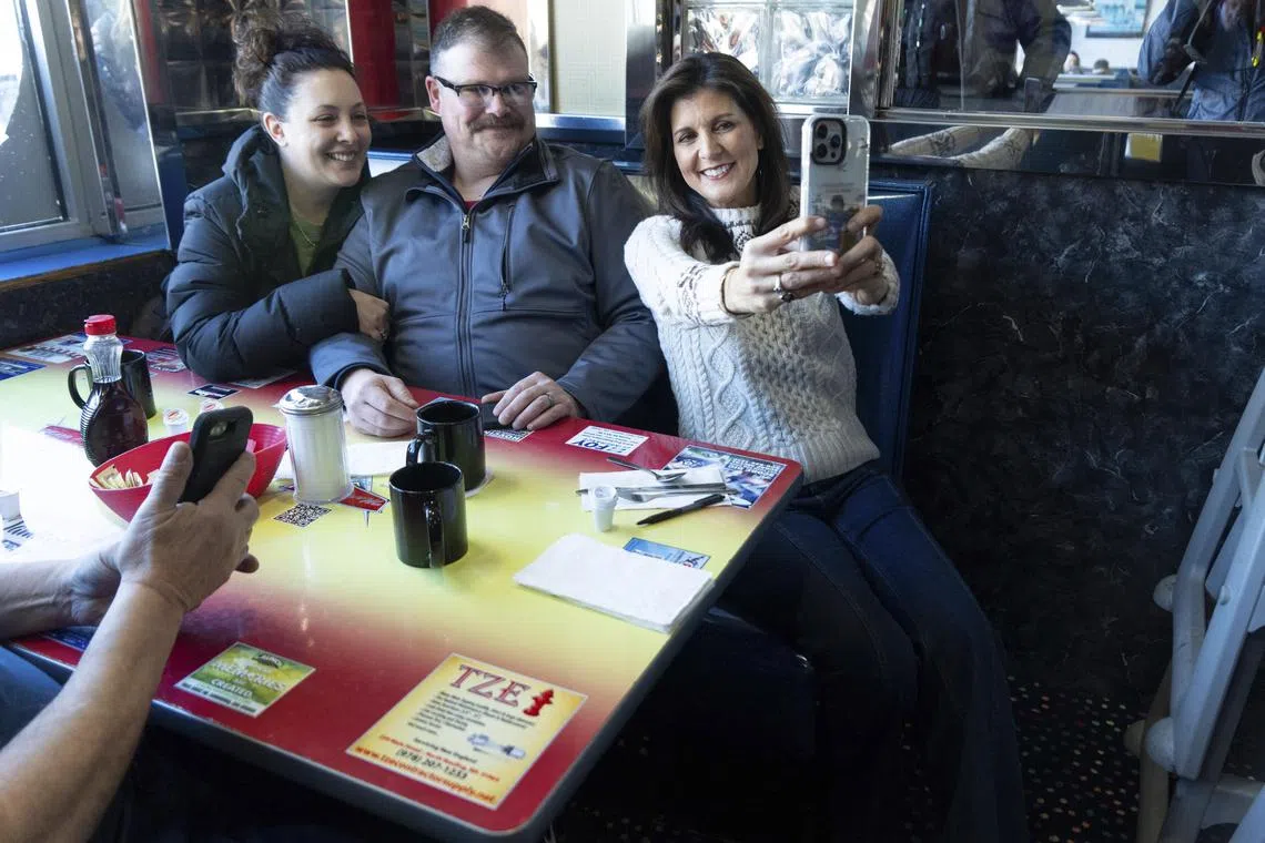 Republican presidential primary candidate Nikki Haley takes photos with customers at a diner in Derry, New Hampshire.