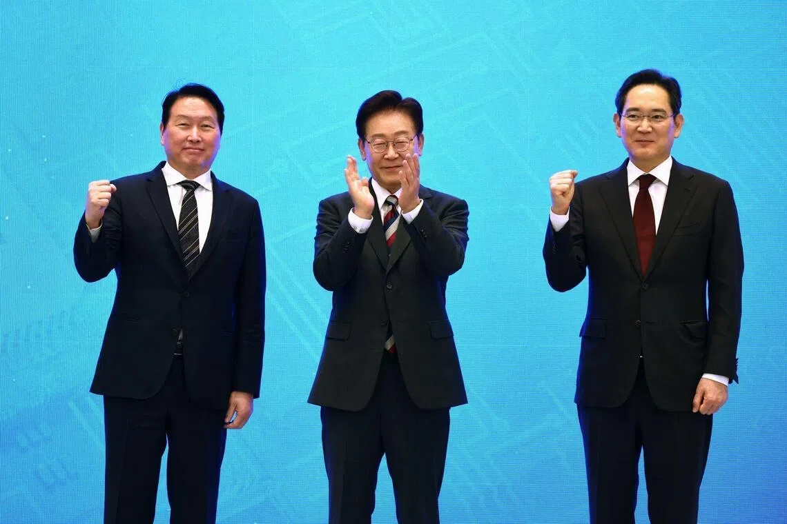 Chey Tae-won, chairman of SK Group, left, Lee Jae Myung, South Korea's president, center, and Jay Y. Lee, chairman of Samsung Electronics Co., pose for photographs during a news conference at the presidential Blue House in Seoul, South Korea, on Monday, June 29, 2026. South Korea unveiled an ambitious plan aimed at cementing its status as a technological powerhouse, with companies led by Samsung Electronics Co. and SK Hynix Inc. initiating large-scale investments in memory chips, data centers and robotics. Photographer: SeongJoon Cho/Bloomberg