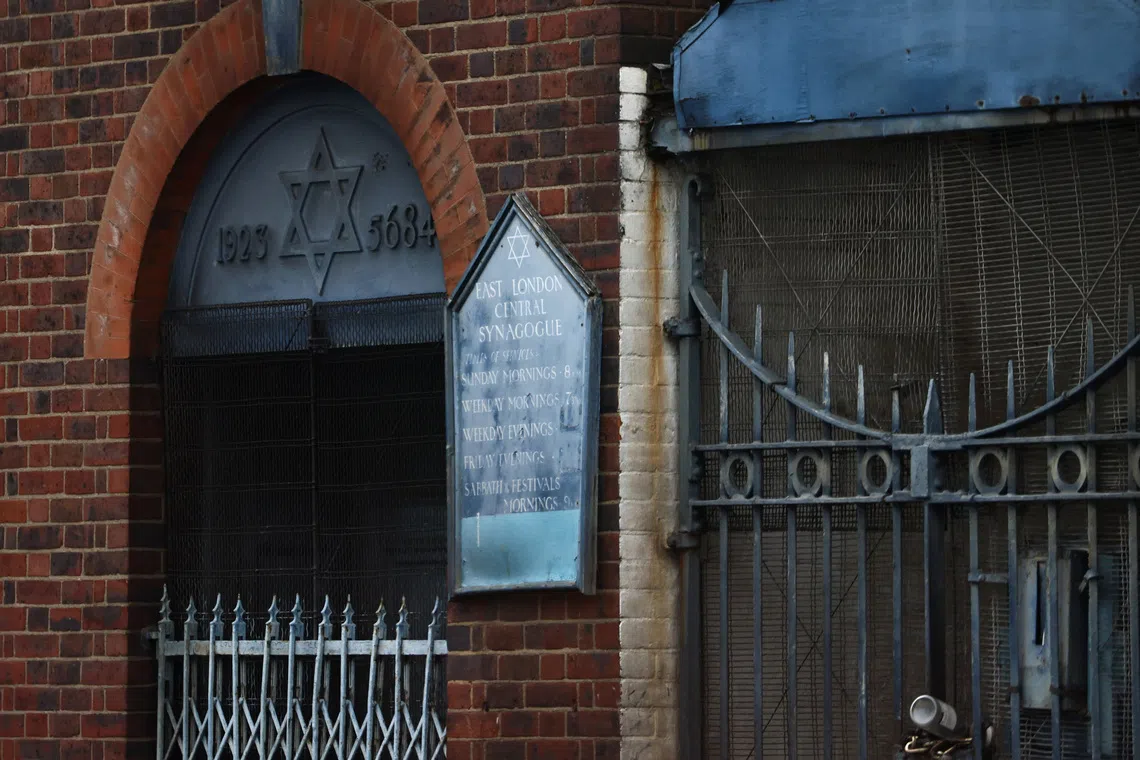 A sign hangs at the site of a suspected arson attack on a former synagogue in London.
