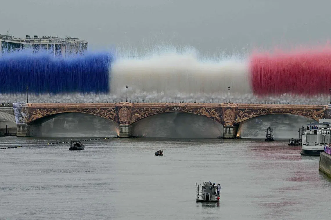 Fireworks in the French national colours explode over Pont d'Austerlitz, which crosses the Seine River, during the opening ceremony.