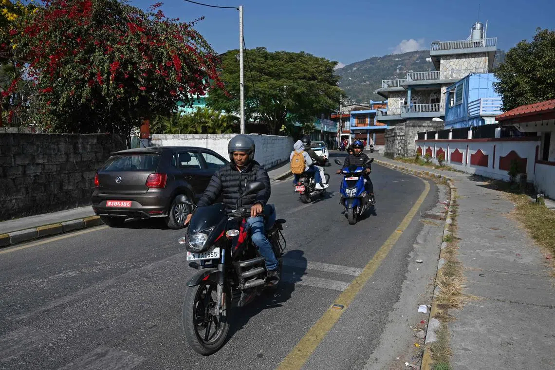 Vehicles driving on a road built using recycled plastic waste in Pokhara, Nepal. 