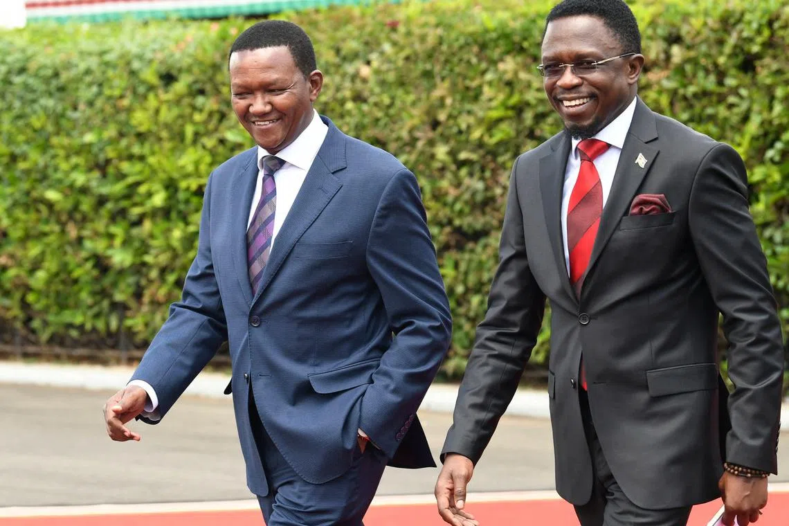 Kenya's cabinet secretary for youth affairs, sports and the arts, Ababu Namwamba (right) and his counterpart Alfred Mutua, roreign and diaspora affairs, smile after their swearing-in ceremony of new Cabinet Secretaries at the State House in Nairobi on Oct 27.