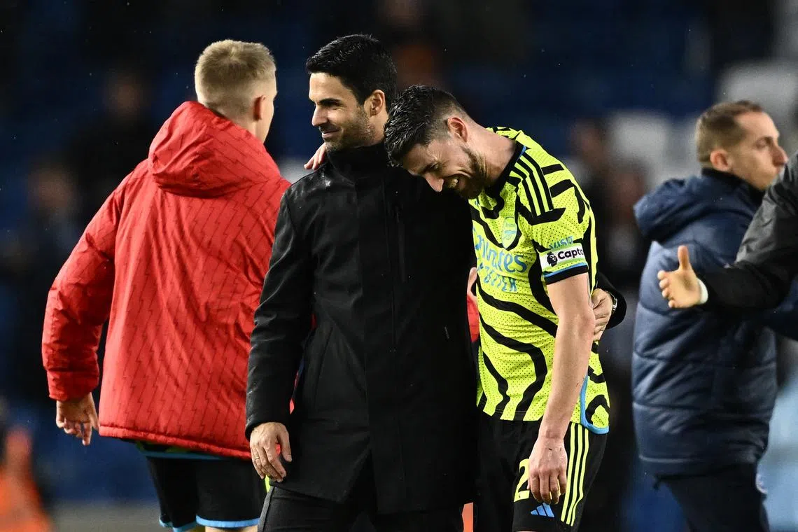 FILE PHOTO: Soccer Football - Premier League - Brighton & Hove Albion v Arsenal - The American Express Community Stadium, Brighton, Britain - April 6, 2024 Arsenal manager Mikel Arteta celebrates with Jorginho after the match REUTERS/Dylan Martinez/File Photo
