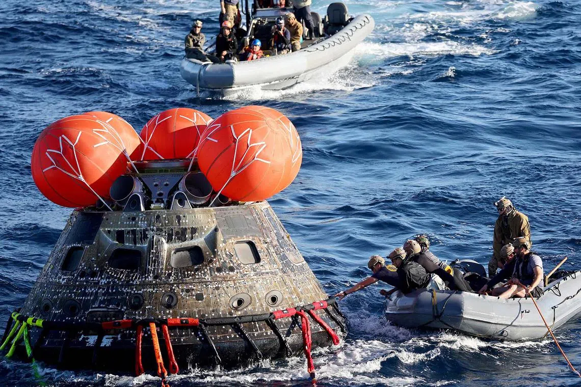 US Navy divers secure NASA's Orion Capsule during recovery operations following a successful uncrewed Artemis I moon mission after it splashed down in the Pacific Ocean off the coast of Baja California, Mexico, on Dec 11, 2022. 