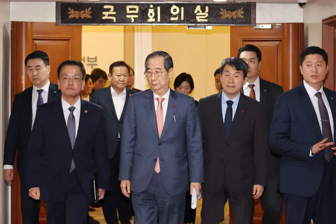 If President Yoon Suk Yeol quits or is removed from office then, under the constitution, Prime Minister Han Duck-soo (centre) will step in to perform presidential duties.
