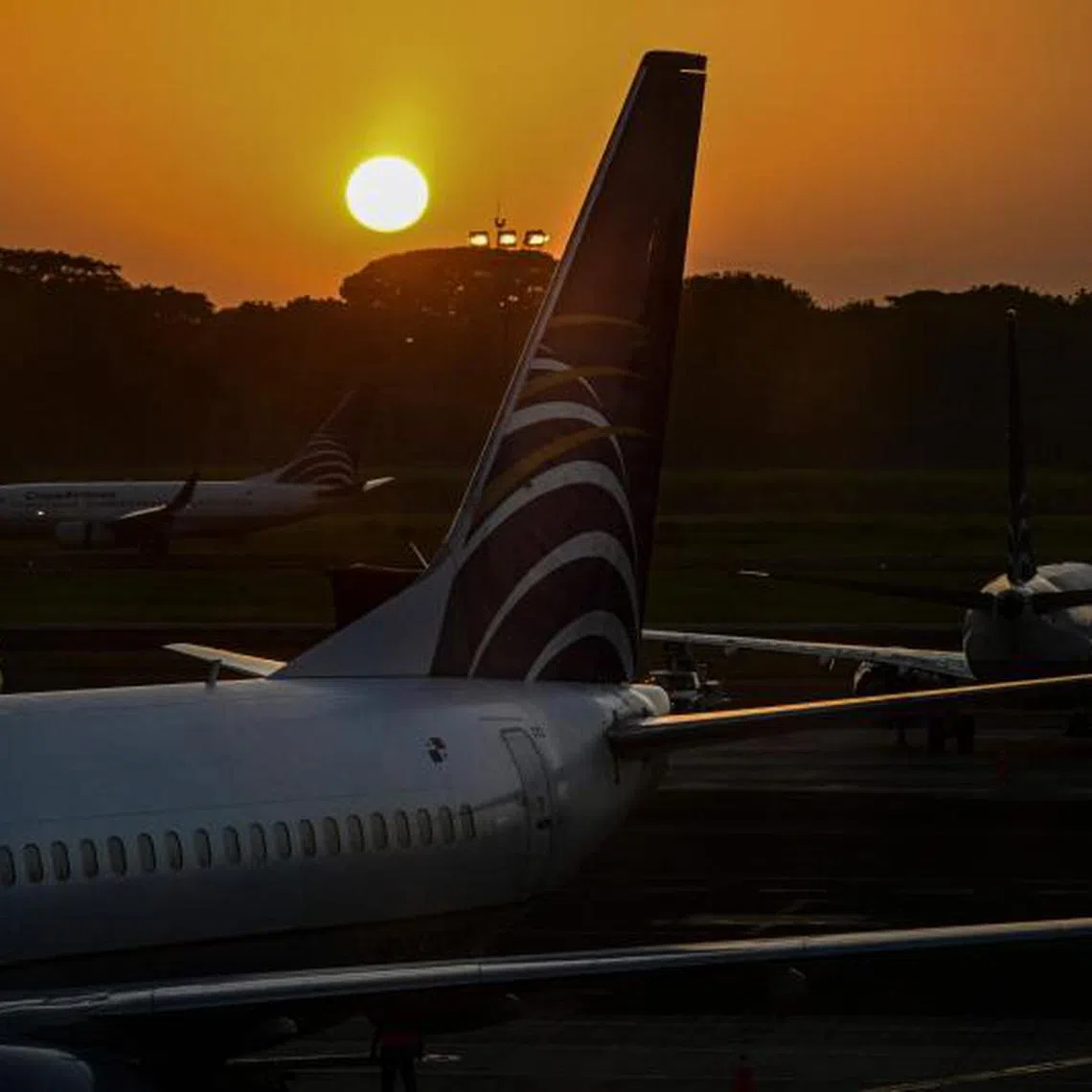 (FILES) Aircrafts of Panamanian carrier Copa Airlines are seen during sunrise at Tocumen International Airport in Panama City on January 12, 2024. Panama's civil aviation authority on May 22, 2025, announced that it would resume flights with Venezuela after nearly a year, facilitating the repatriation of Venezuelan migrants expelled from the United States. (Photo by Martin BERNETTI / AFP)