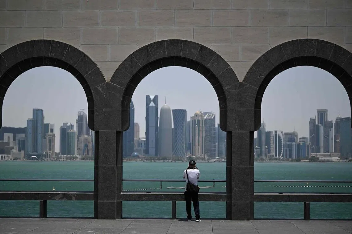 TOPSHOT - A visitor to the Museum of Islamic Art takes pictures of the skyline of highrise buildings in Doha on July 9, 2026. The United States and Iran traded strikes on July 9 for the second day running as Washington and Tehran battled over the strategic Strait of Hormuz. The Iranian army said it had targeted sites in Kuwait, Bahrain and Qatar with one-way attack drones as part of its attacks on US bases in the Gulf, state TV reported. (Photo by AFP) / Attention editors: AFP covers the war in the Middle East through its extensive regional network, including bureaus in Tehran, Jerusalem and several neighboring countries.Since the start of the conflict, journalists have been working under increasingly restrictive conditions. Authorities in several countries have limited reporters’ movements, photo and live video coverage from sensitive locations. Some governments and armed groups have banned images of missile or drone strikes and other security-related sites. /
