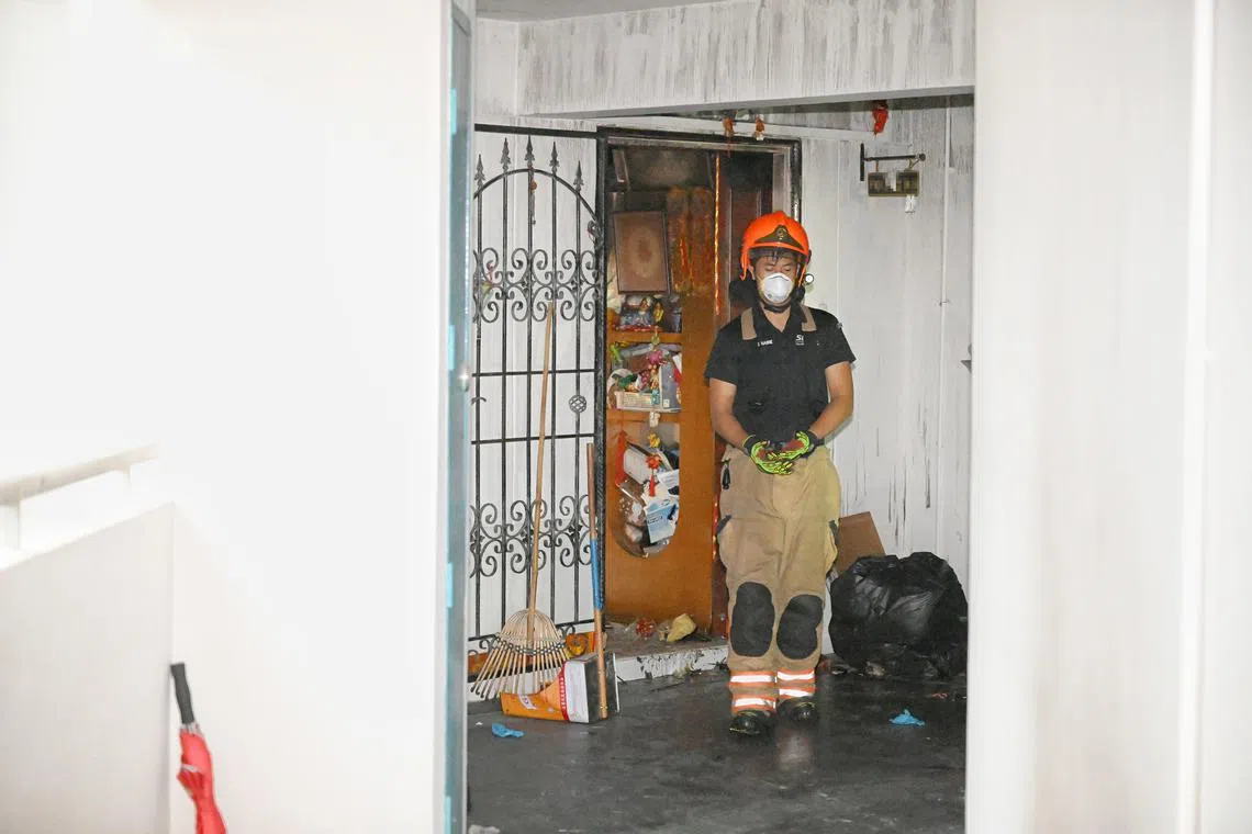 A firefighter at a flat in Block 971 Hougang Street 91 on Jan 10, a day after a fire broke out at the unit.
