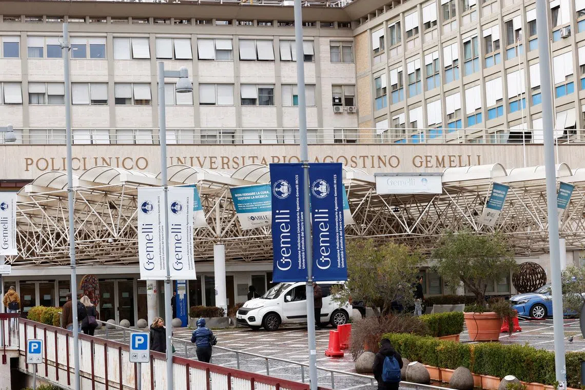 People walk outside the Gemelli Hospital where Pope Francis is hospitalised for bronchitis treatment in Rome, Italy, February 15, 2025. REUTERS/Ciro De Luca