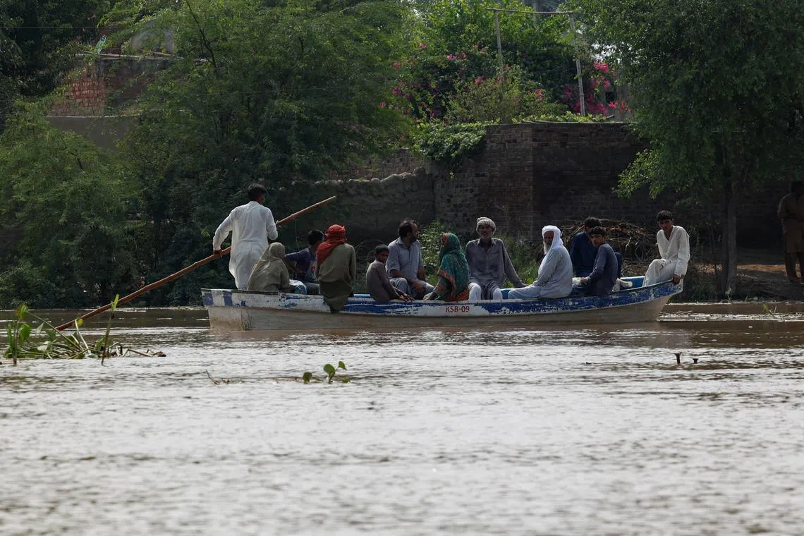 FILE PHOTO: Residents use a boat to reach their destination in flooded areas due to the monsoon rains and rising water level of the Sutlej River, in Hakuwala village near the Pakistan-India border in Kasur district of the Punjab province, Pakistan August 23, 2025. REUTERS/Akhtar Soomro/File Photo