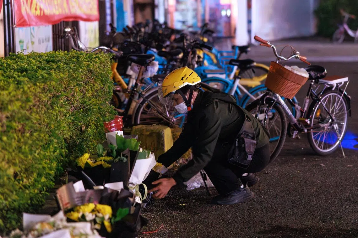A man places flowers at a stadium where 35 people were killed in one of China’s deadliest mass-casualty events in years.
