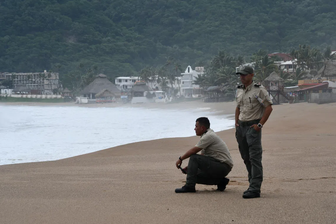 Jalisco Civil Protection personnel stand on a beach as Hurricane Polo, last classified as a Category 4 storm, moves northwest offshore, in Melaque, Jalisco state, Mexico, September 24, 2026. REUTERS/Liberto Urena