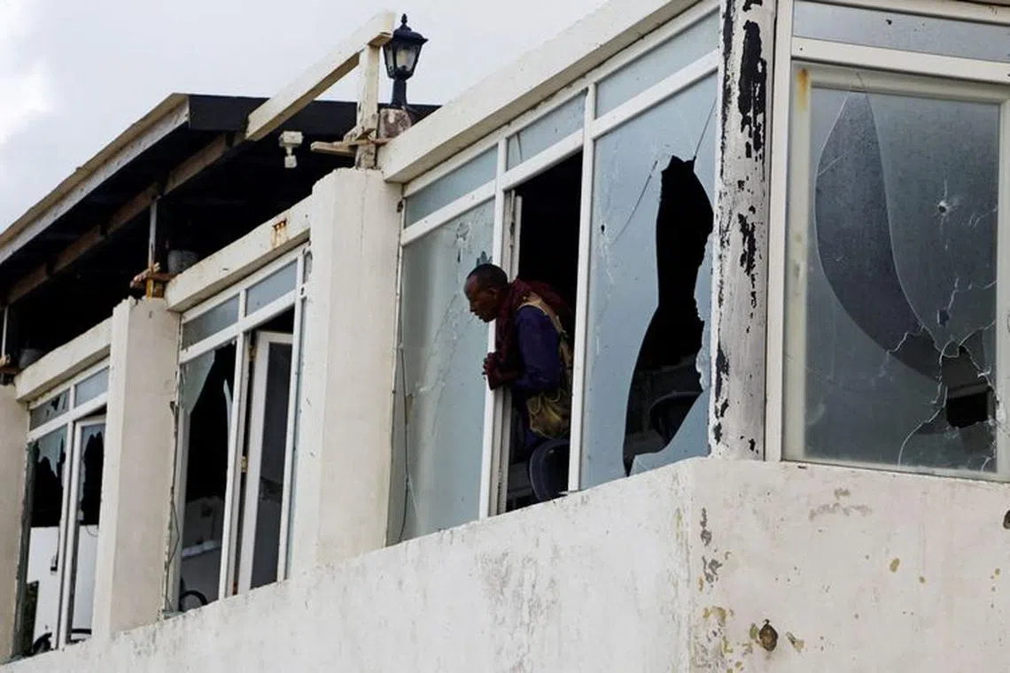 FILE PHOTO: A Somali police officer looks from the broken windows of the Pearl Beach Restaurant following an attack by Al Shabaab militants at the Liido beach in Mogadishu, Somalia June 10, 2023. REUTERS/Feisal Omar/File Photo