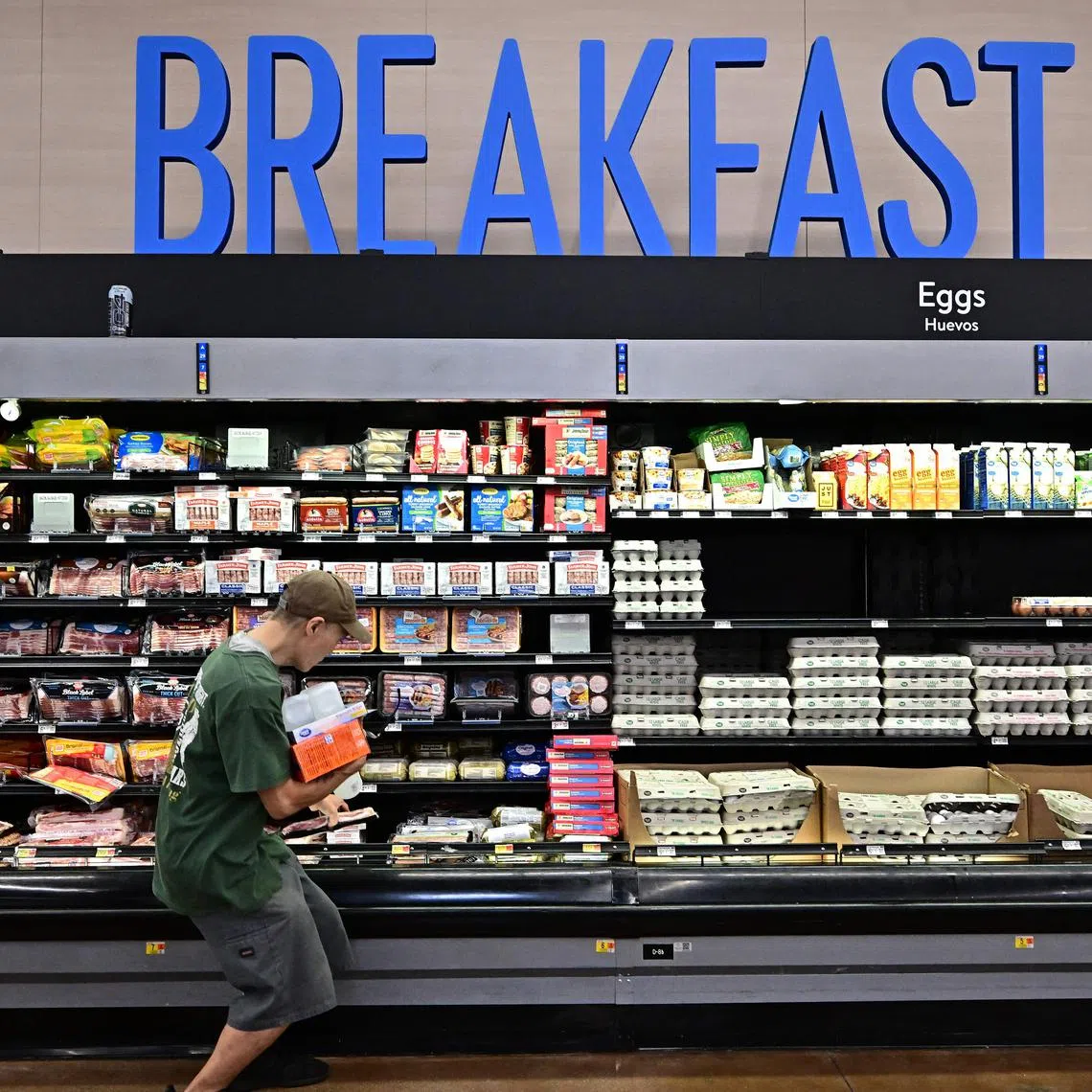 (FILES) A shopper picks up his package of bacon while shopping for food items at a grocery store on August 14, 2024 in Rosemead, California. Donald Trump's US election victory was, at least in part, down to his success in pinning the blame for a post-pandemic inflationary surge on the Biden-Harris administration. But analysts say some of Trump's own economic plans, from hiking tariffs to reining in the Fed's independence, risk undoing the US central bank's progress against inflation, potentially pushing it to keep interest rates higher for longer. (Photo by Frederic J. BROWN / AFP)