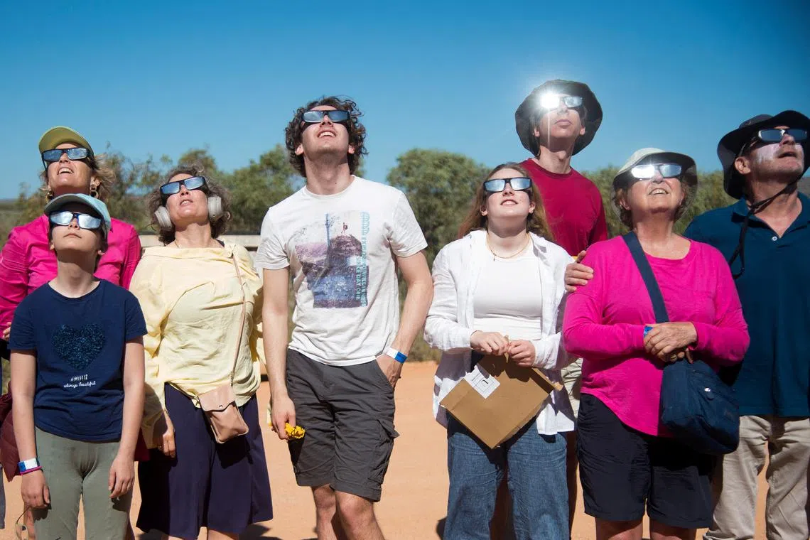 People watch a total solar eclipse at a viewing site 35km from Exmouth, Western Australia, April 20, 2023. A