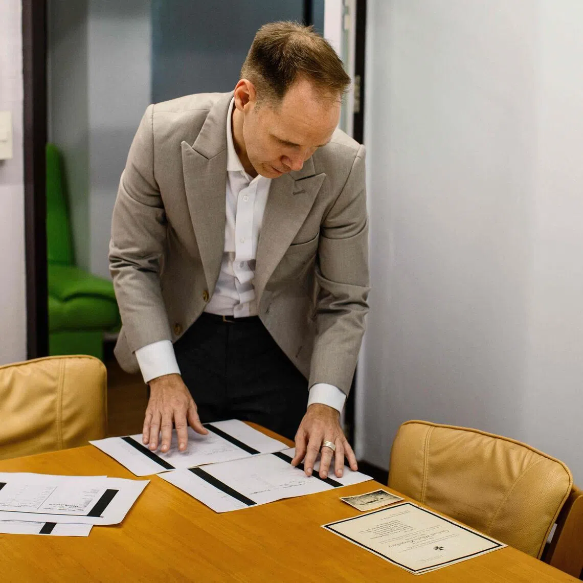German lecturer Felix Puelm looks at copies of National Socialist German Workers’ party membership cards of several members of his family, at Silpakorn University in Nakhon Pathom province, west of Bangkok, on June 2. 