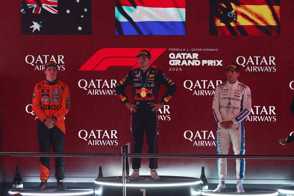 Red Bull’s Max Verstappen (centre) stands on the podium after winning the 2025 Qatar Grand Prix alongside second placed McLaren’s Oscar Piastri and third placed Williams’ Carlos Sainz Jr.