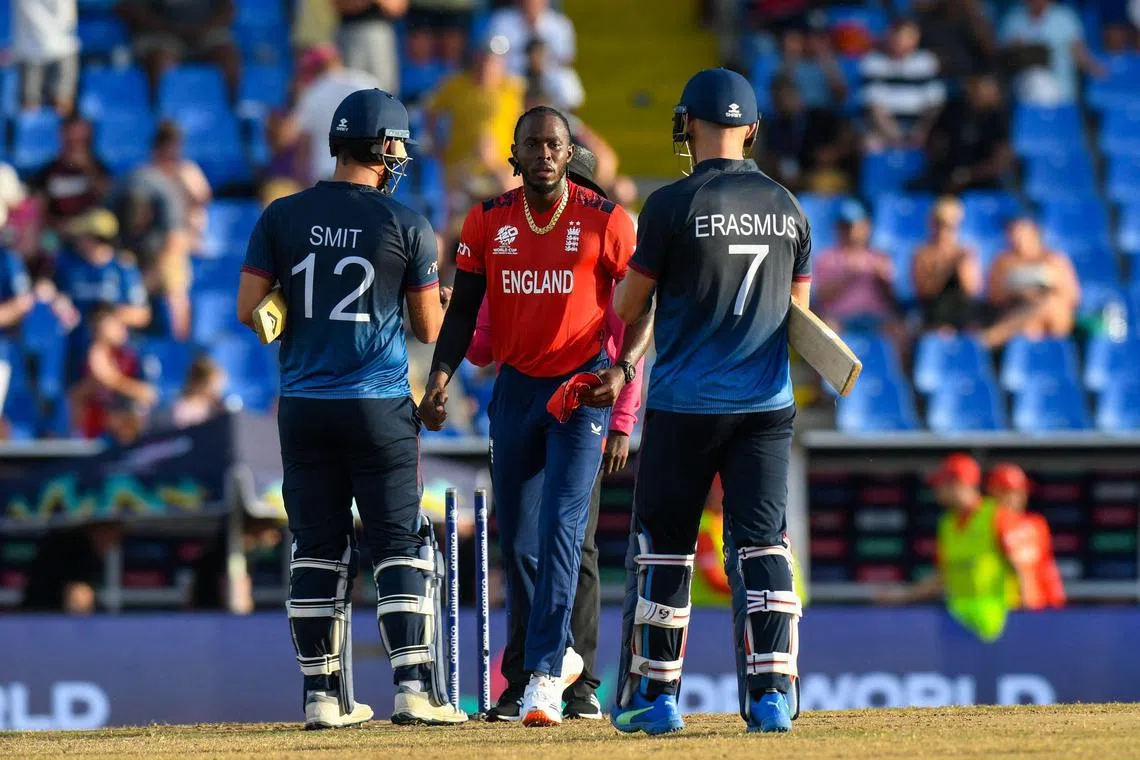 Namibia's J.J. Smit and captain Gerhard Erasmus congratulate Jofra Archer after England won their Twenty20 World Cup group B cricket match at Sir Vivian Richards Stadium in North Sound, Antigua and Barbuda on June 15, 2024. 