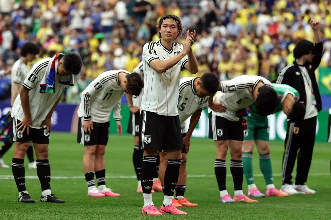 Japan captain Kou Itakura and teammates bowing to their fans after losing 2-1 to Brazil in the World Cup round of 32 on June 29.