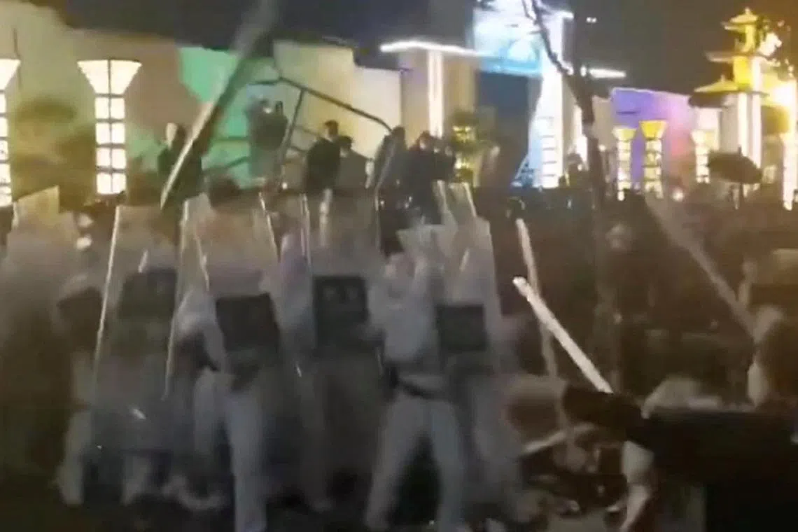 Security forces clash with workers during a protest outside Apple supplier Foxconn's factory in Zhengzhou, China, on Nov 23, 2022. The world’s biggest iPhone factory is battling production shortfalls and labour unrest spurred largely by Beijing’s harsh virus containment policies.