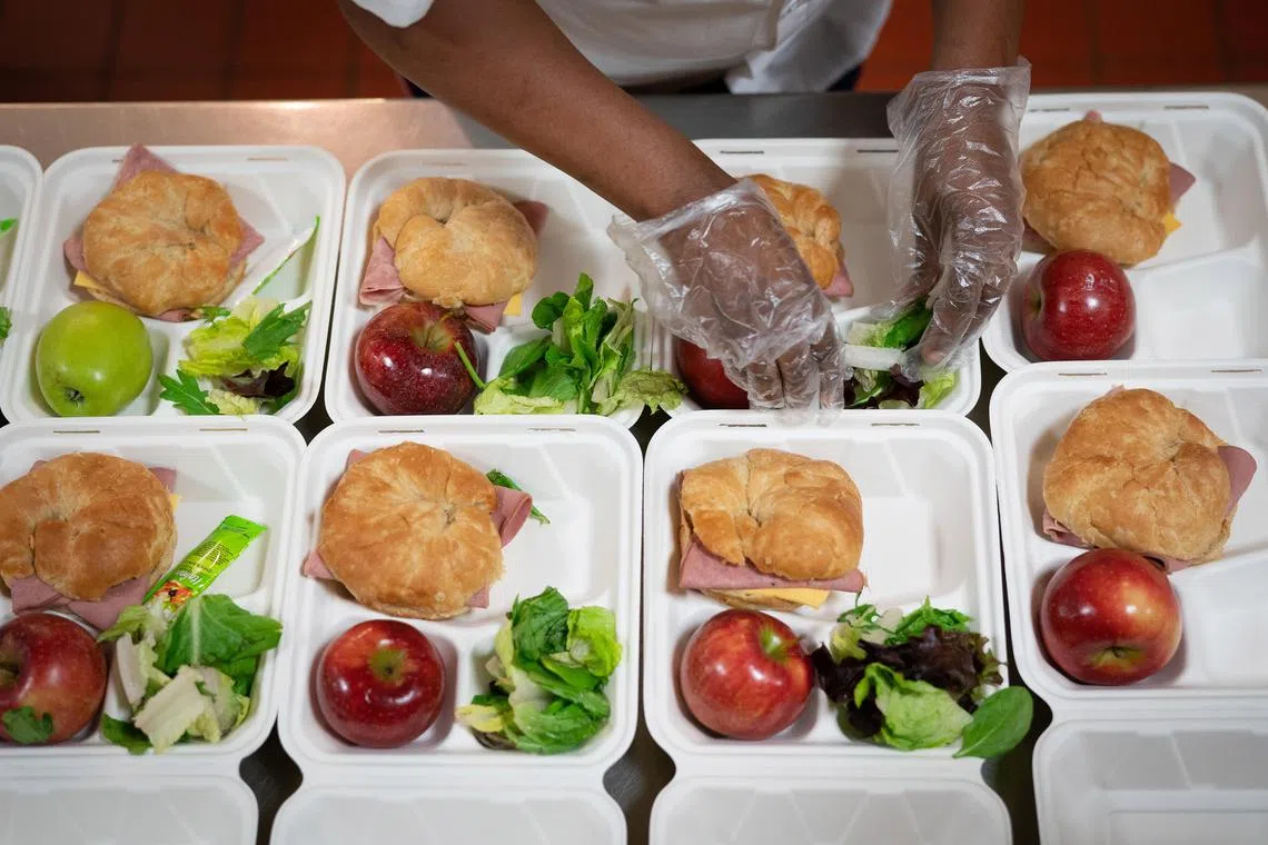 FILE Ñ A cafeteria worker prepares lunches at an elementary school in Baltimore, April 14, 2020. Interventions like expanding physical activity and nutrition programs in schools have not been enough to prevent weight gain and obesity in children and adolescents, scientists say. (Erin Schaff/The New York Times)