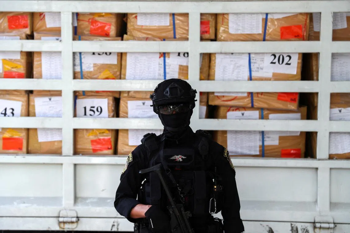 FILE PHOTO: A police officer from the Narcotics Control Board stands guard in front of boxes of confiscated drugs during the 50th Destruction of Confiscated Narcotics ceremony in Ayutthaya province, Thailand, June 26, 2020. REUTERS/Athit Perawongmetha/File Photo