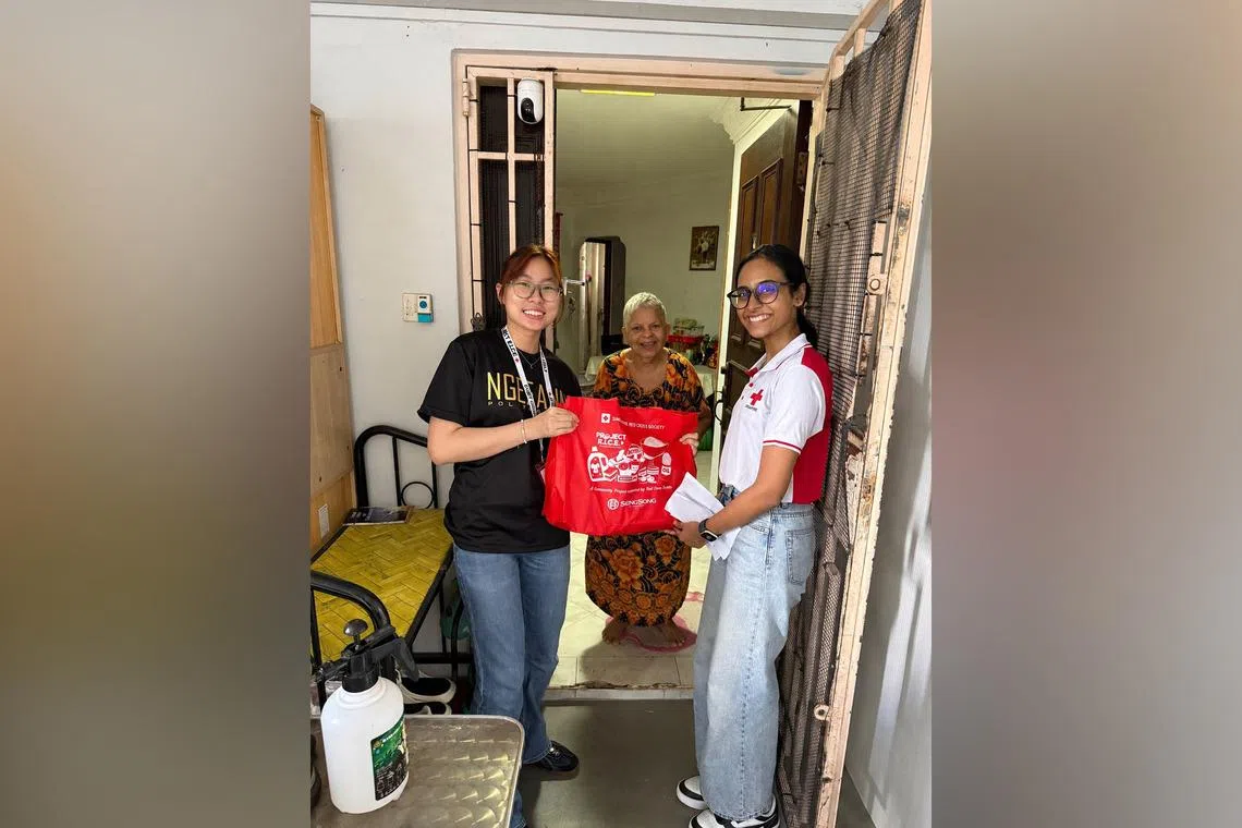 (Left) Lim Jing and Sanchari Das (right) with a beneficiary. In all, 570 volunteers were involved in the packing and distribution of the household items.