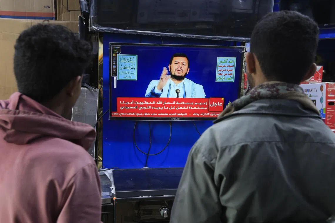 People watch top Houthi leader, Abdul-Malik al-Houthi, delivering a TV speech in Sana'a, Yemen, 18 Jan, 2024. 